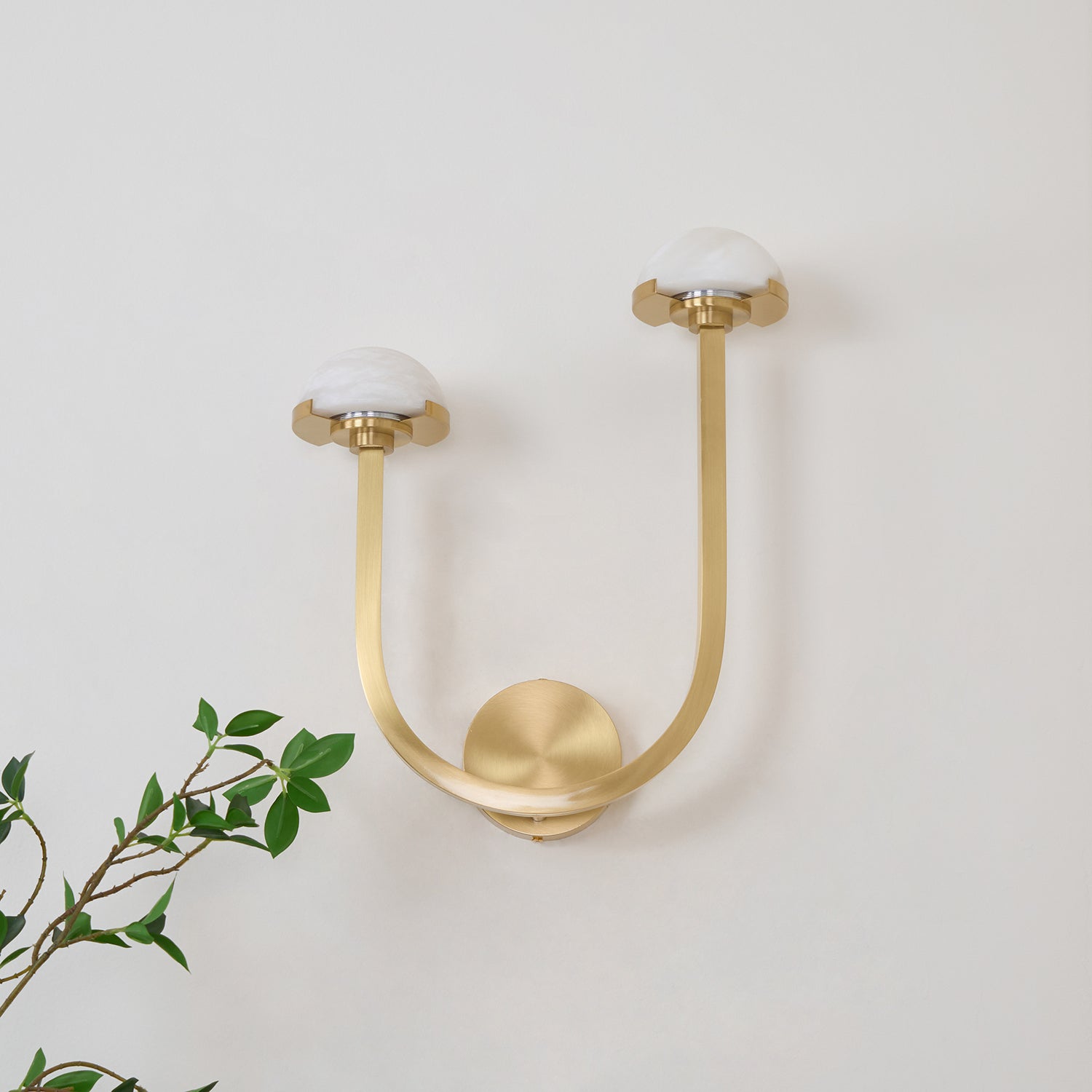 Vitalira Double Alabaster Wall Light in brushed brass on a white wall, domes unlit and chalky white.