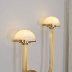 Both alabaster domes of the brass Vitalira wall light lit, throwing soft pools of light on the wall.