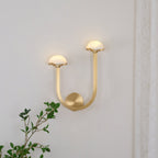 Brass Vitalira Double Alabaster Wall Light lit on a white wall, one dome set higher than the other.