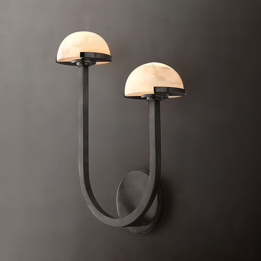 Vitalira Double Alabaster Wall Light in black lit against a charcoal backdrop, both domes glowing.