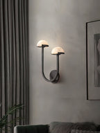 Vitalira Double Alabaster Wall Light in black lit in a living room beside grey curtains and framed art.