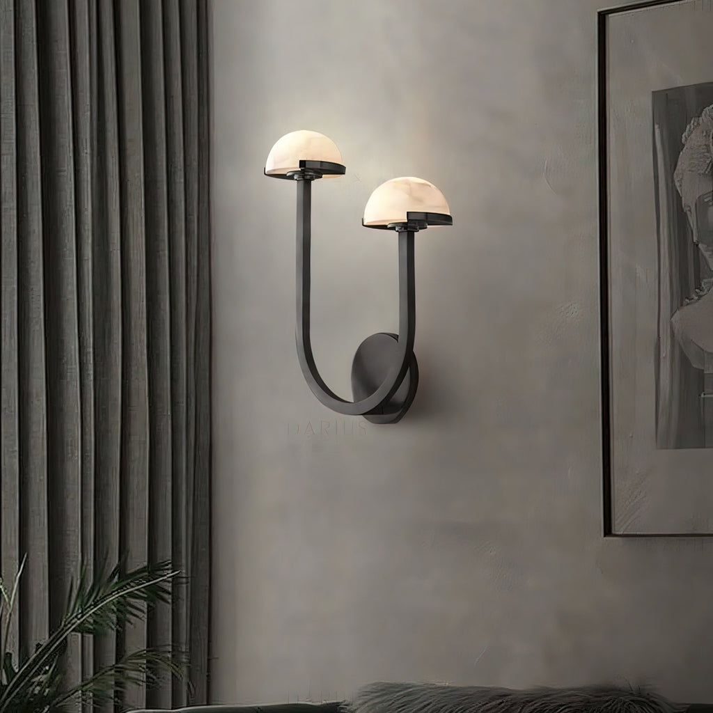 Black Vitalira Double Alabaster Wall Light lit in a living room, curtains left and framed art right.