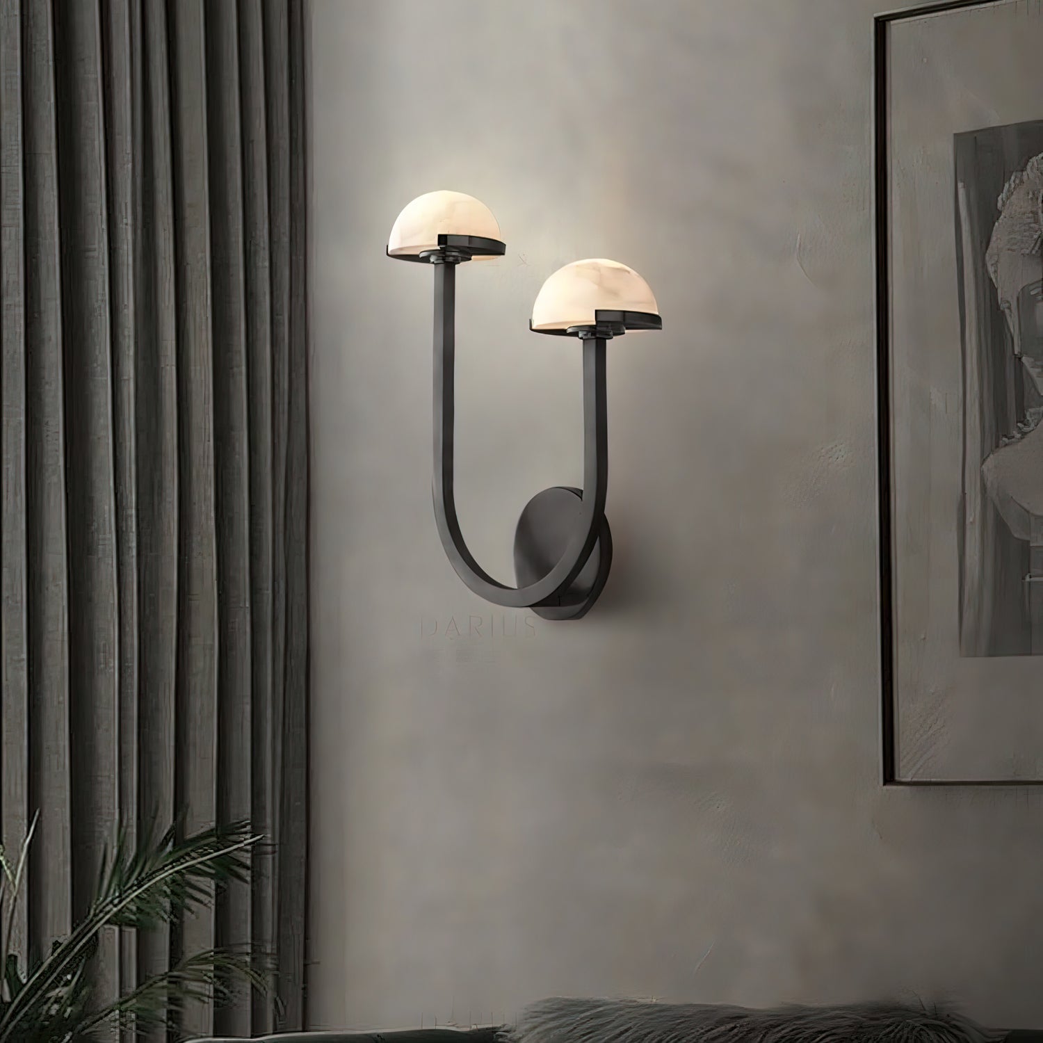 Black Vitalira Double Alabaster Wall Light lit in a living room, curtains left and framed art right.