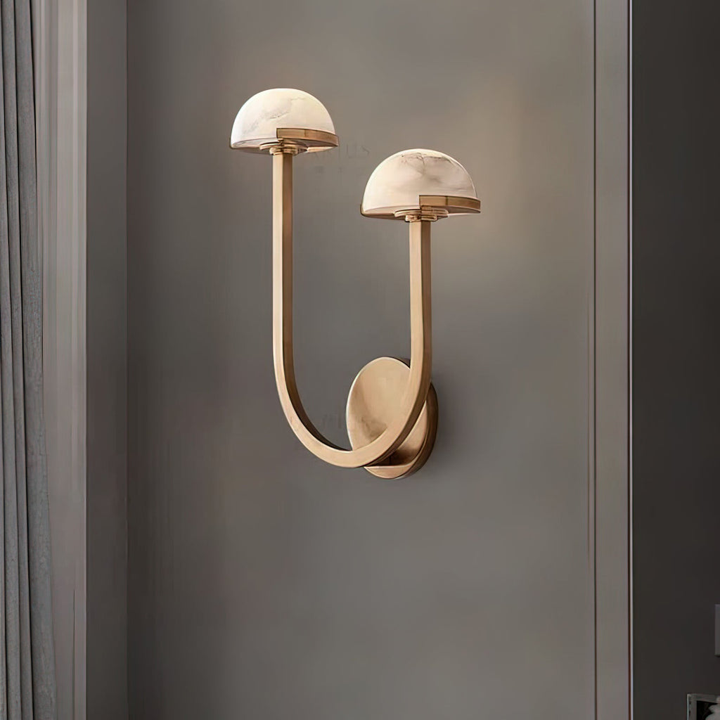 Brass Vitalira Double Alabaster Wall Light lit on a grey wall beside a painted window surround.