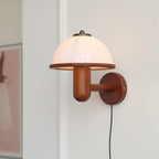 Mushroom wall lamp casting warm light across a textured wall