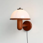 Mushroom wall lamp shown mounted at eye level on a pale wall
