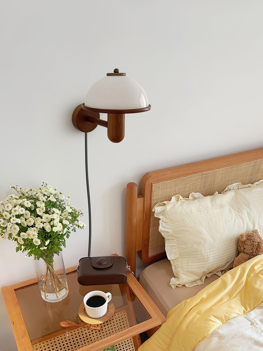 Mushroom wall lamp lit beside a bed for a warm bedtime glow