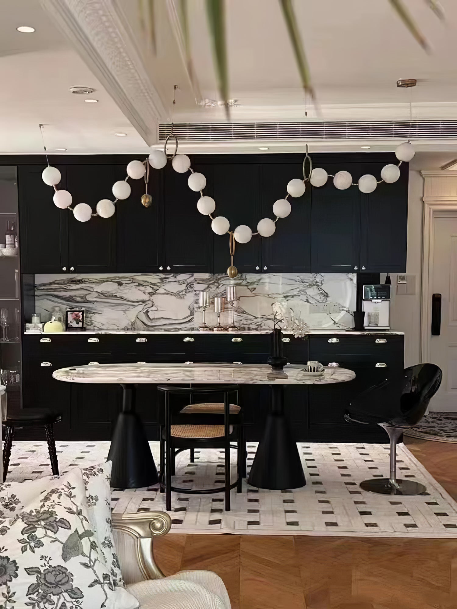 Necklace pendant light with white globes in a styled room
