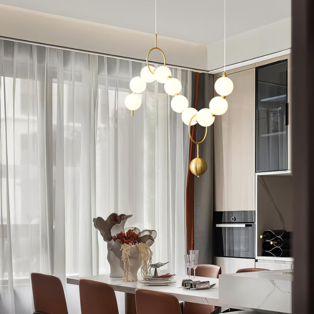 Necklace pendant light with gold frame and lit glass globes