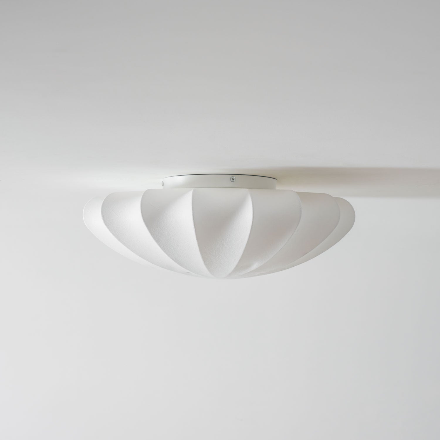 Nelson Bubble ceiling lamp shown lit, the silk diffusing warm ambient light