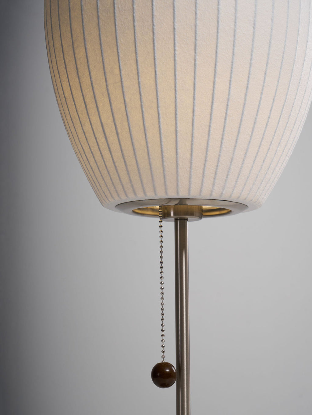 Chrome-stemmed faux silk bubble table lamp glowing in a cosy living room
