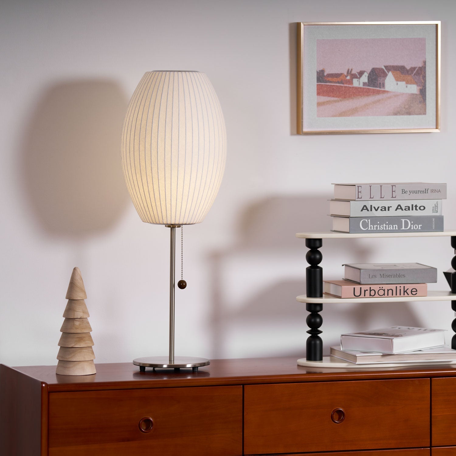 Faux silk bubble table lamp with chrome stem lit warmly on a side table