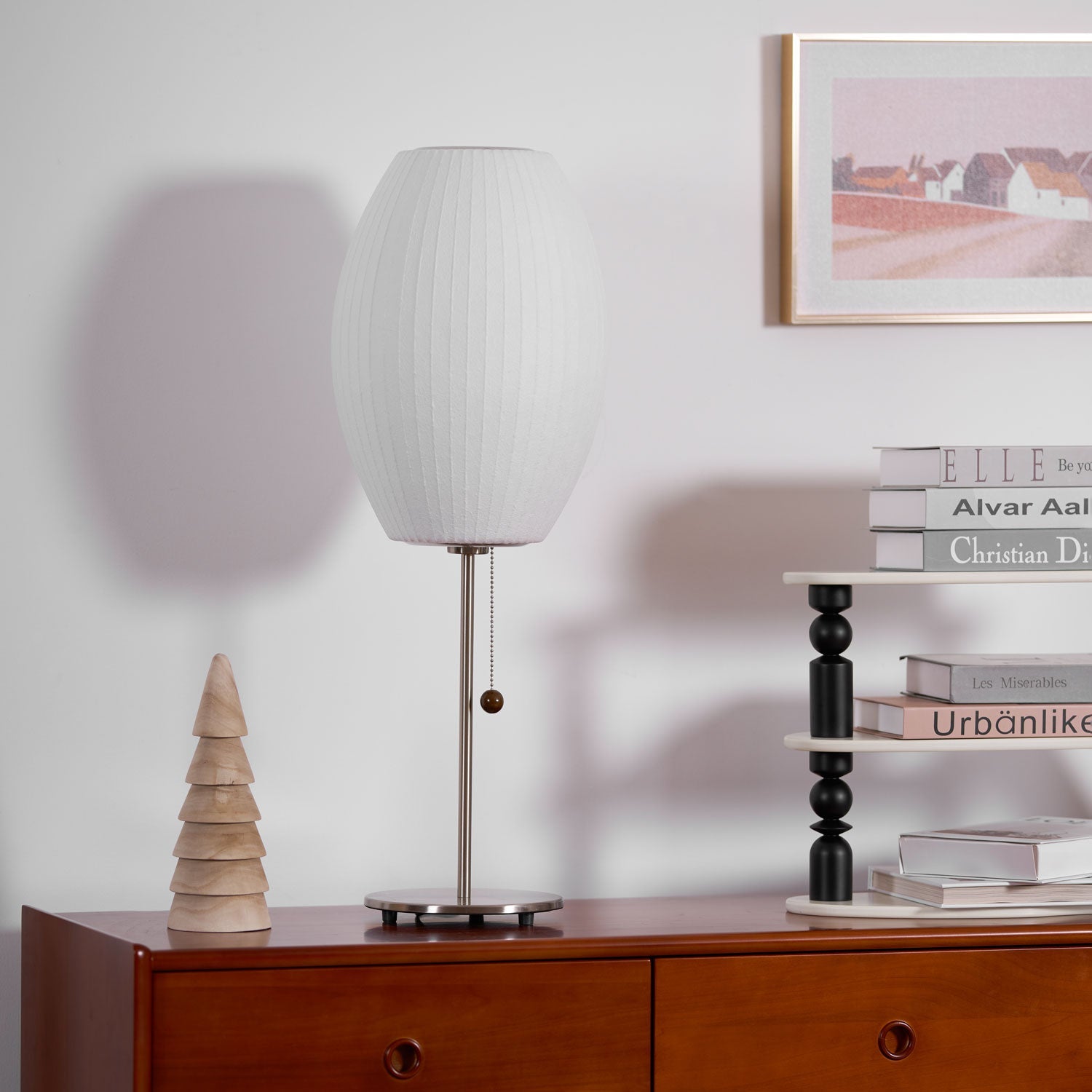 Faux silk bubble table lamp with chrome stem lit warmly on a side table