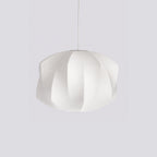 White silk bubble pendant light glowing warmly above seating