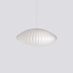 White mulberry silk bubble pendant light glowing above a dining table