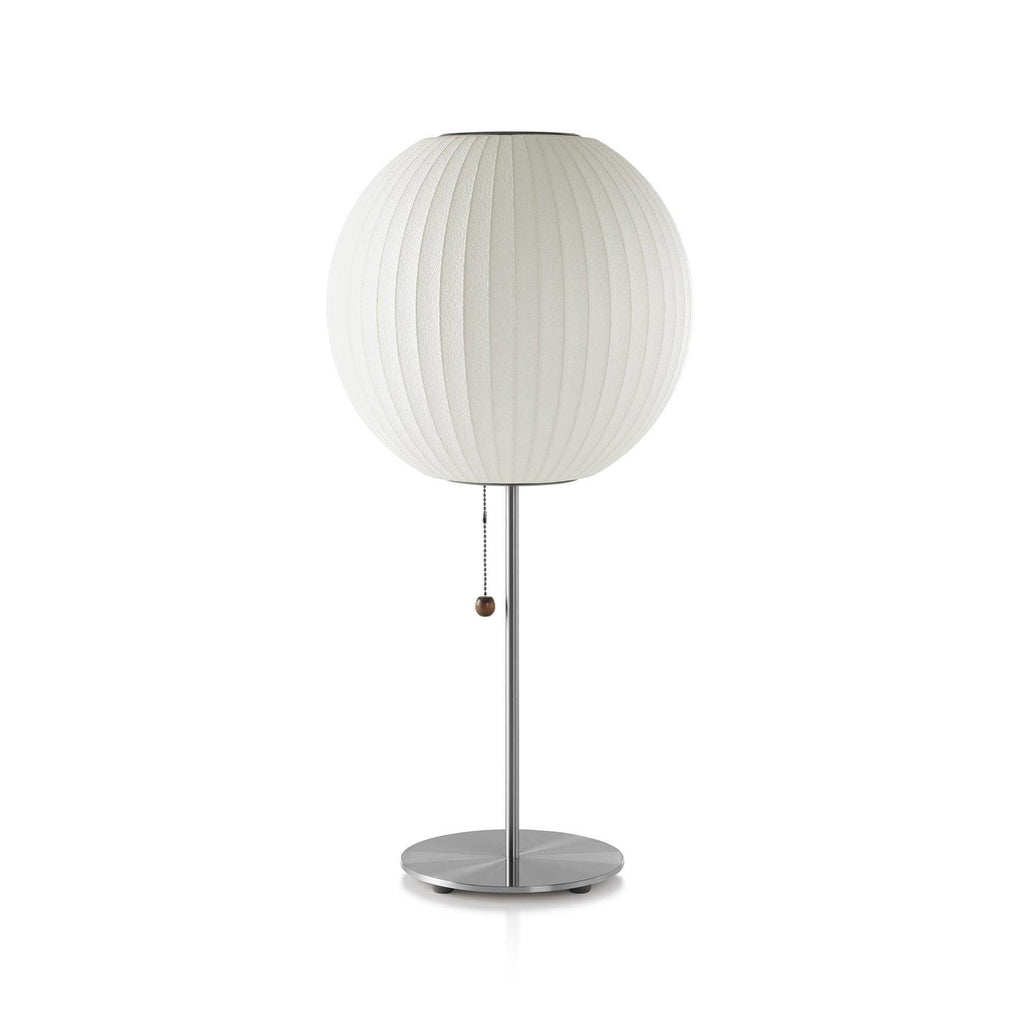 Faux silk bubble table lamp with chrome stem lit warmly on a side table