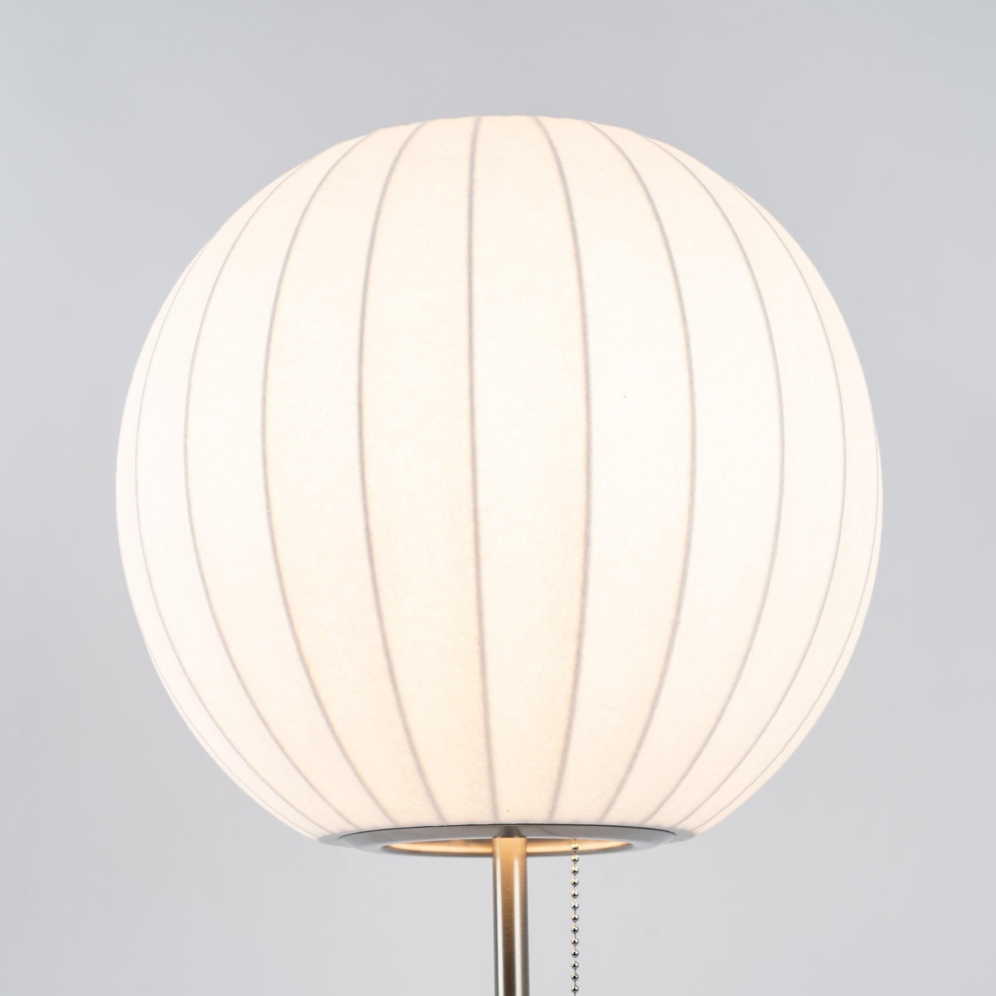 Chrome-stemmed faux silk bubble table lamp glowing in a cosy living room