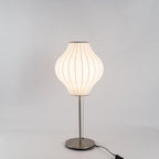 Faux silk bubble table lamp on a bedside table casting a soft diffused glow