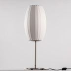 Chrome-stemmed faux silk bubble table lamp glowing in a cosy living room