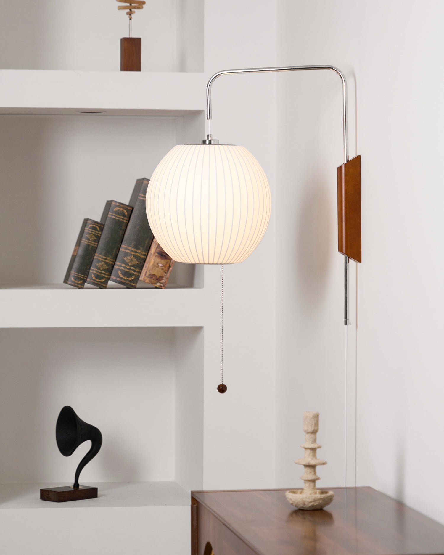 White polymer wall sconce with walnut accent in styled setting