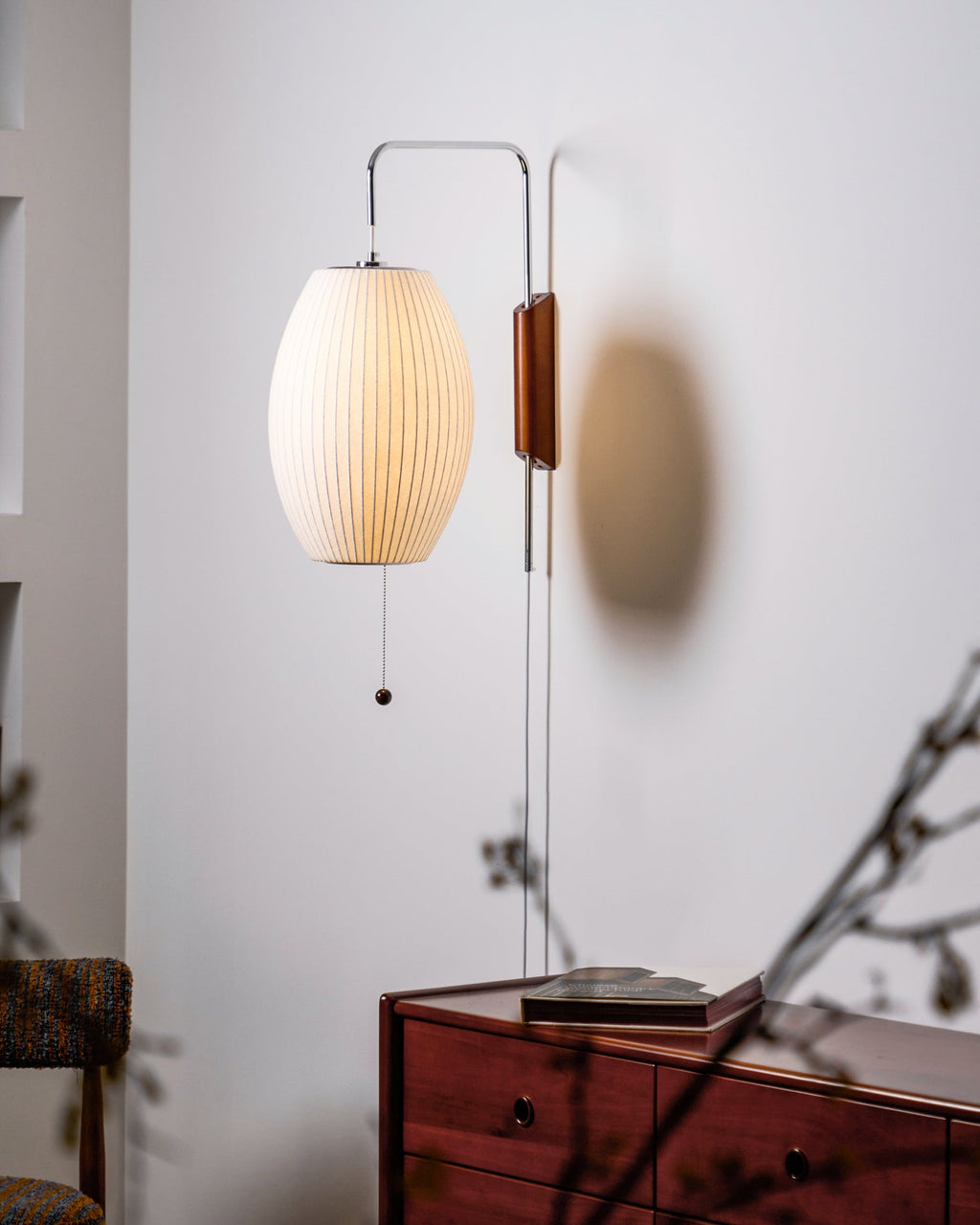 White sphere wall sconce shown in interior with warm bulb glow