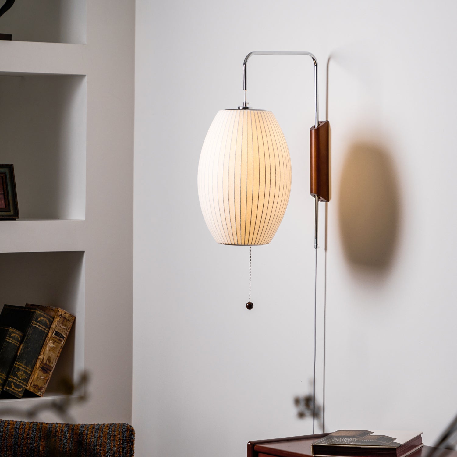 White wall sconce sphere lit softly above a side table