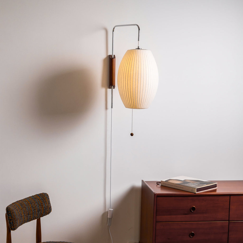 White sphere wall sconce glowing warmly in a cozy room corner