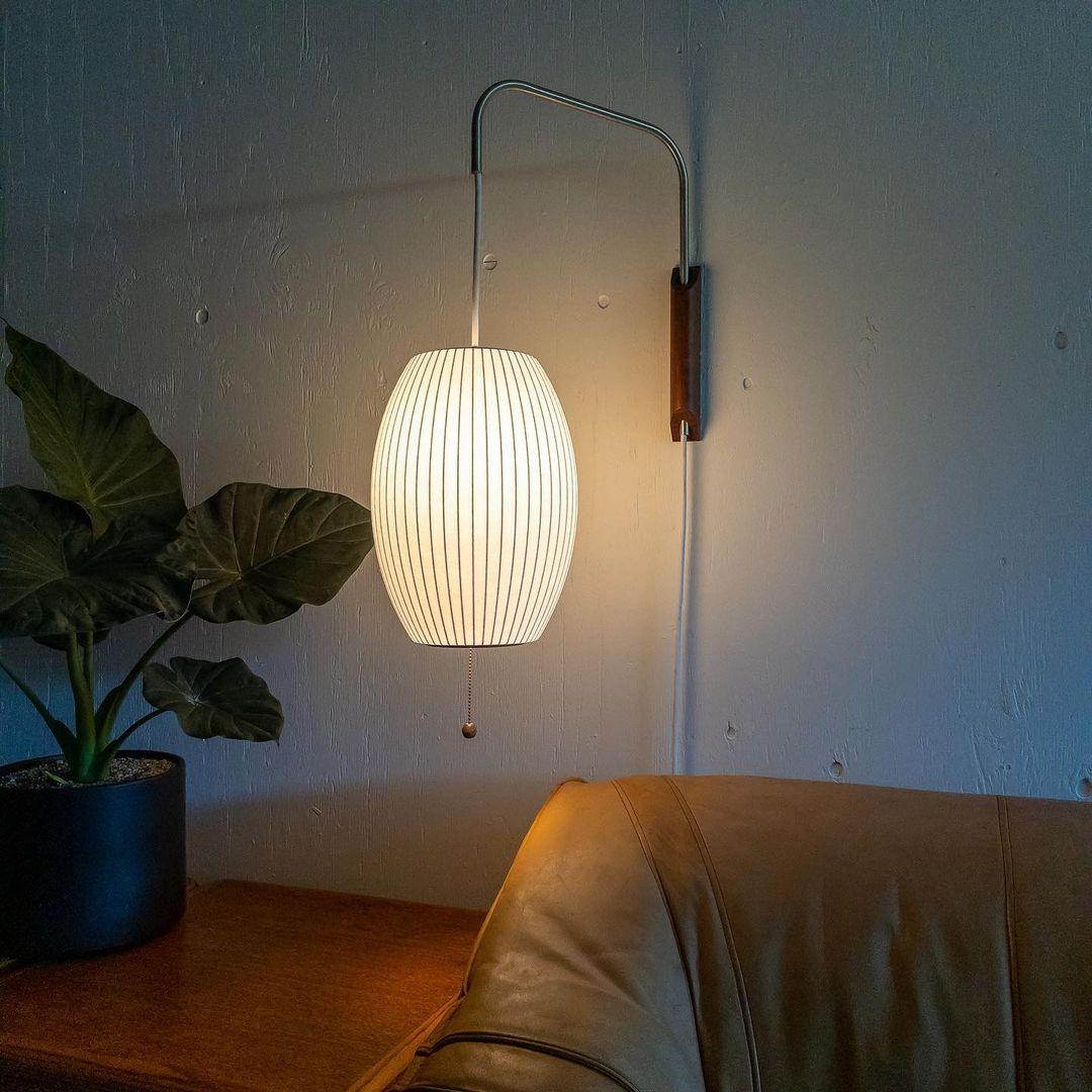 White ball wall sconce with chrome arm extended from wall bracket