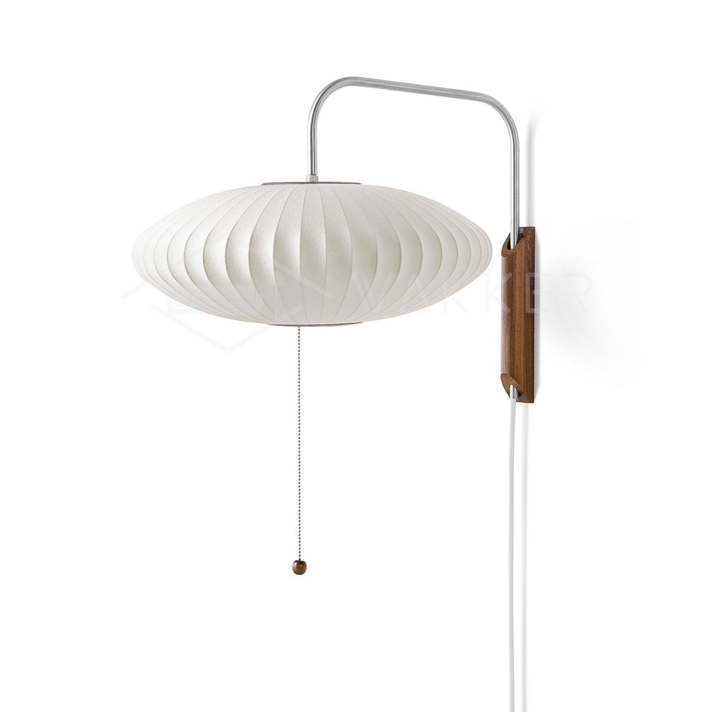 White polymer wall sconce angled on its swivel hinge beside seating