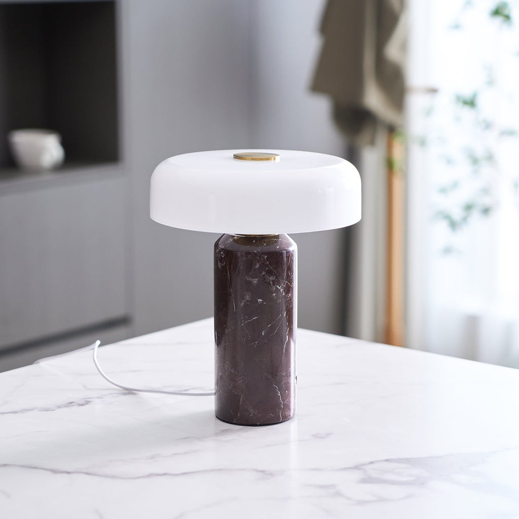 Cordless marble table lamp lit on a dark surface