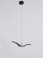A black bird-shaped pendant from this Clérachic light drops on a long cord from a black ceiling canopy, on a grey backdrop.