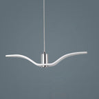 A white bird-shaped pendant from this Clérachic fixture is seen in profile, its slim wings extended, on a dark blue-grey backdrop.