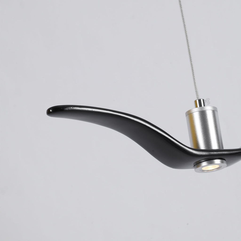 Close view of the nickel neck joint on this black Clérachic bird pendant, its LED lit.