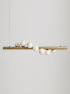 Product shot on a plain background: this Clérachic pendant's brushed brass bar hangs level on two thin cables, alabaster spheres clustered along it.