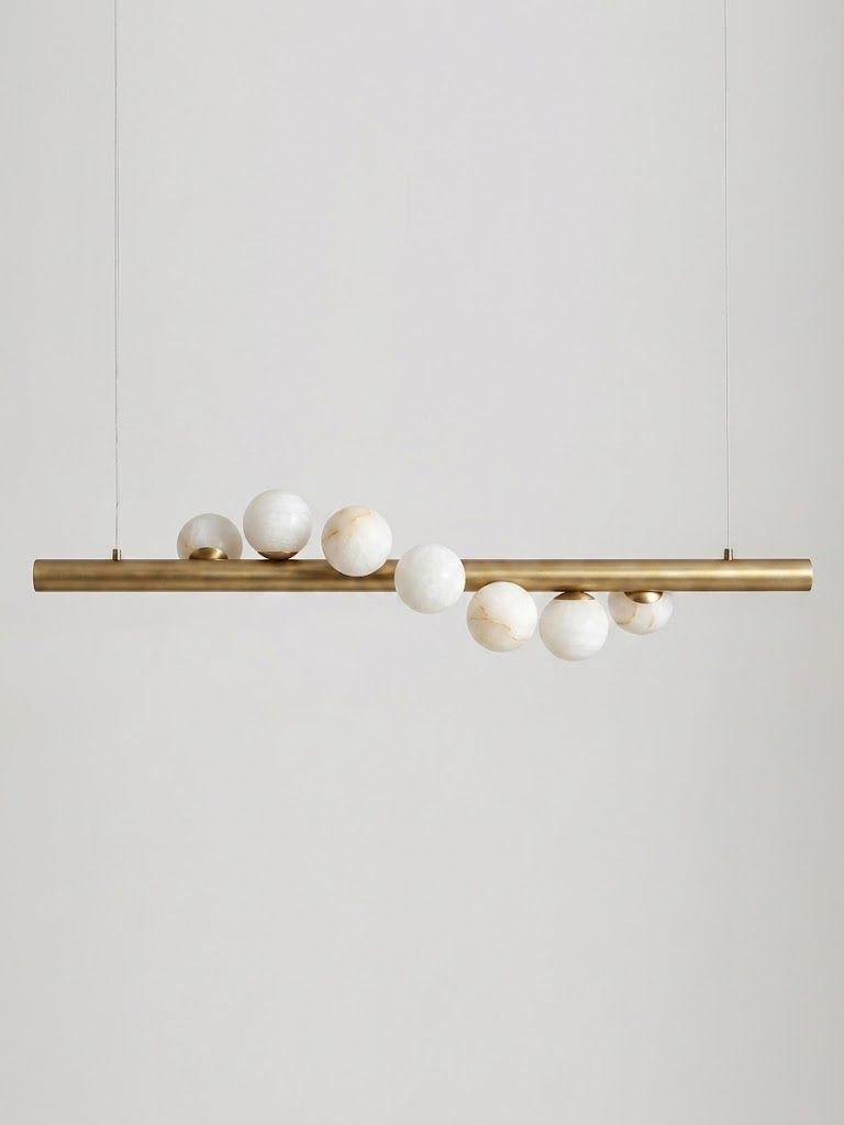 Product shot on a plain background: this Clérachic pendant's brushed brass bar hangs level on two thin cables, alabaster spheres clustered along it.