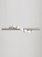 Studio shot on a bare background, this Clérachic pendant's brushed nickel bar holds alabaster spheres of varying sizes.