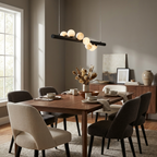 Above a wood table mixing grey and black dining chairs, this Clérachic pendant in matte black hangs level on its bar.