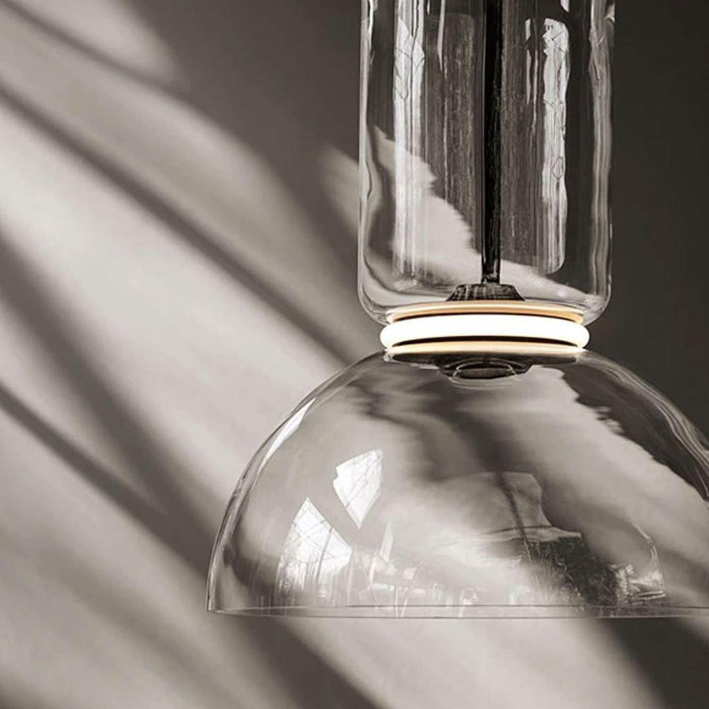 Close-up of this Clérachic pendant's dome-shaped glass shade with sunlight catching its black-ringed cap.
