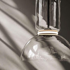 Close-up of this Clérachic pendant's dome-shaped glass shade with sunlight catching its black-ringed cap.
