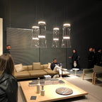 A cluster of glowing cone-shaped pendants from this Clérachic collection hangs above a showroom seating area.
