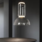 A single dome-shaped clear-glass shade on this Clérachic pendant hangs low above a round table.