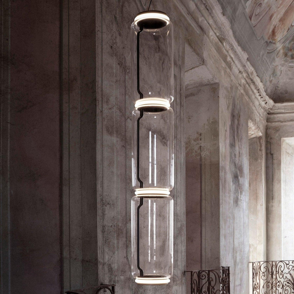 A single stack of five glowing cylinders from this Clérachic pendant lights a weathered stately room.