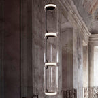 A single stack of five glowing cylinders from this Clérachic pendant lights a weathered stately room.