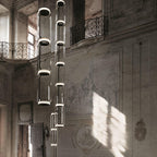 Several long cylinder stacks from this Clérachic pendant hang along a frescoed balcony wall.