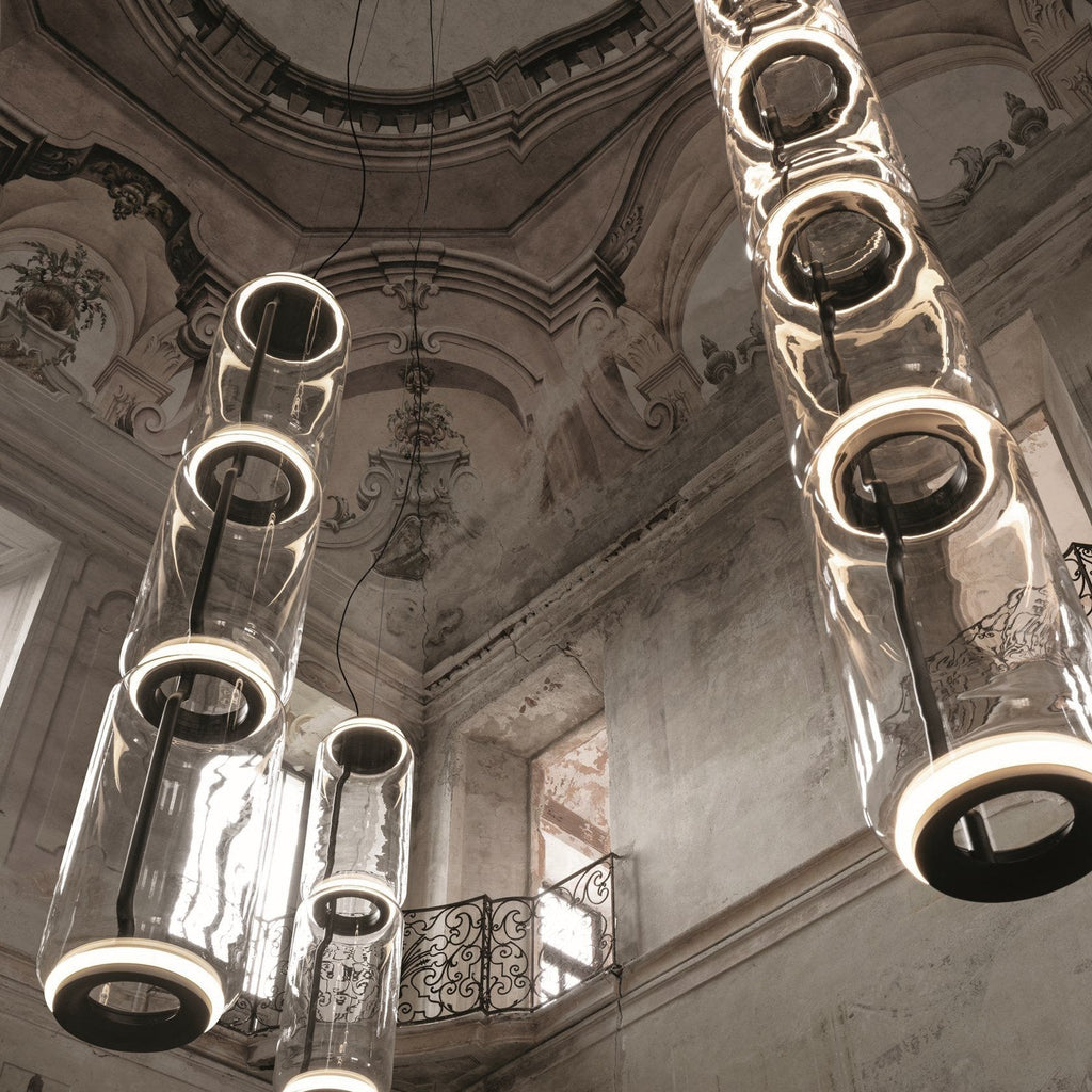 Close view of several cylinder clusters from this Clérachic pendant beneath an ornate frescoed dome ceiling.