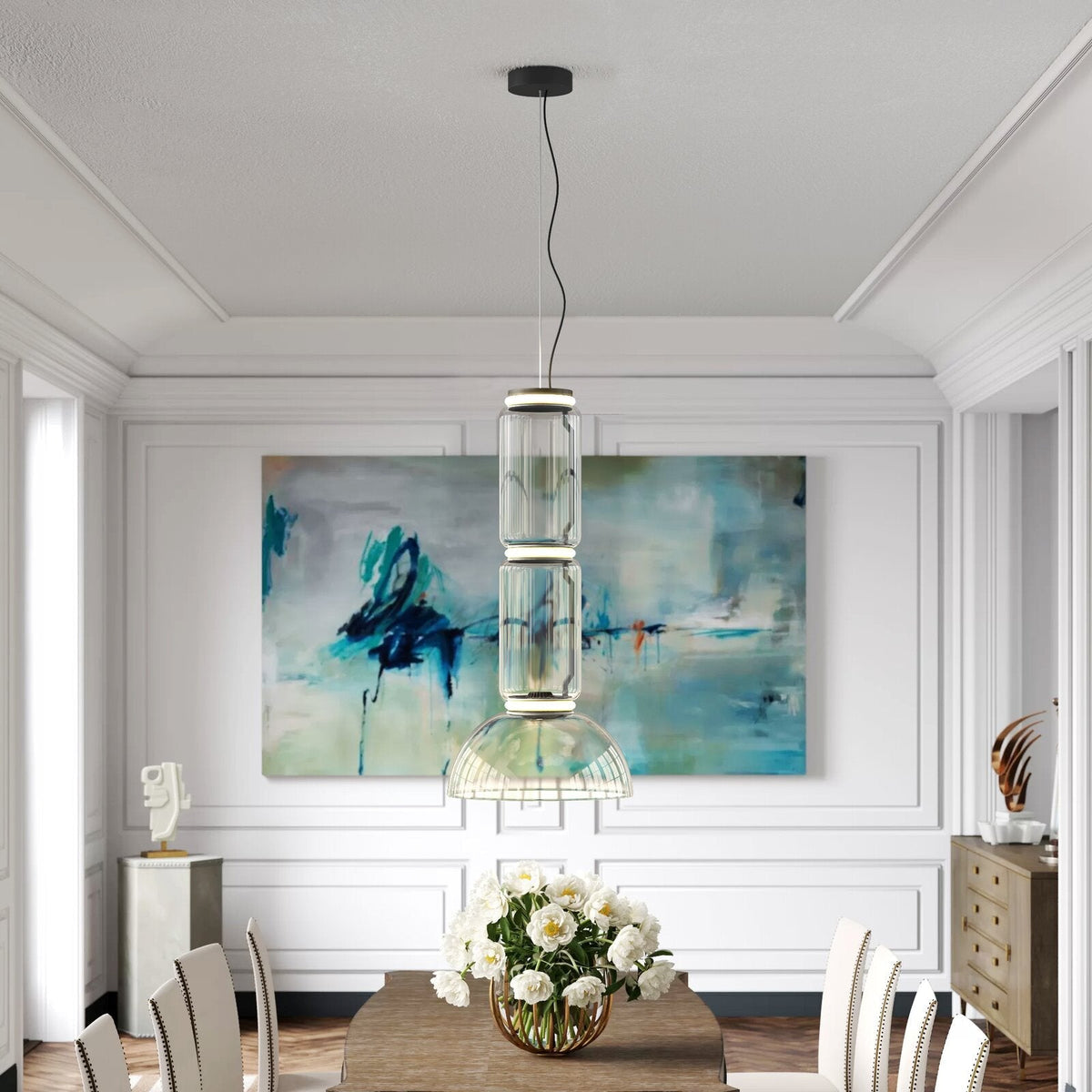 A wire-based cluster of clear glass cylinders from this Clérachic pendant hangs before an abstract painting in a dining room.