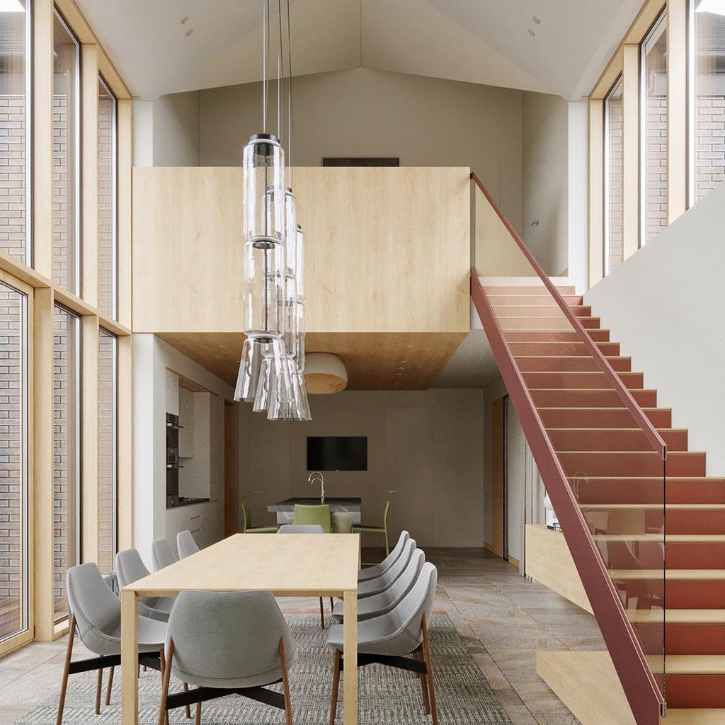 This Clérachic pendant's cluster of dome and cylinder shades hangs above a table beneath a loft stairwell.