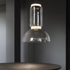 This Clérachic pendant's large dome-shaped shade hangs low above a round table in a dim room.