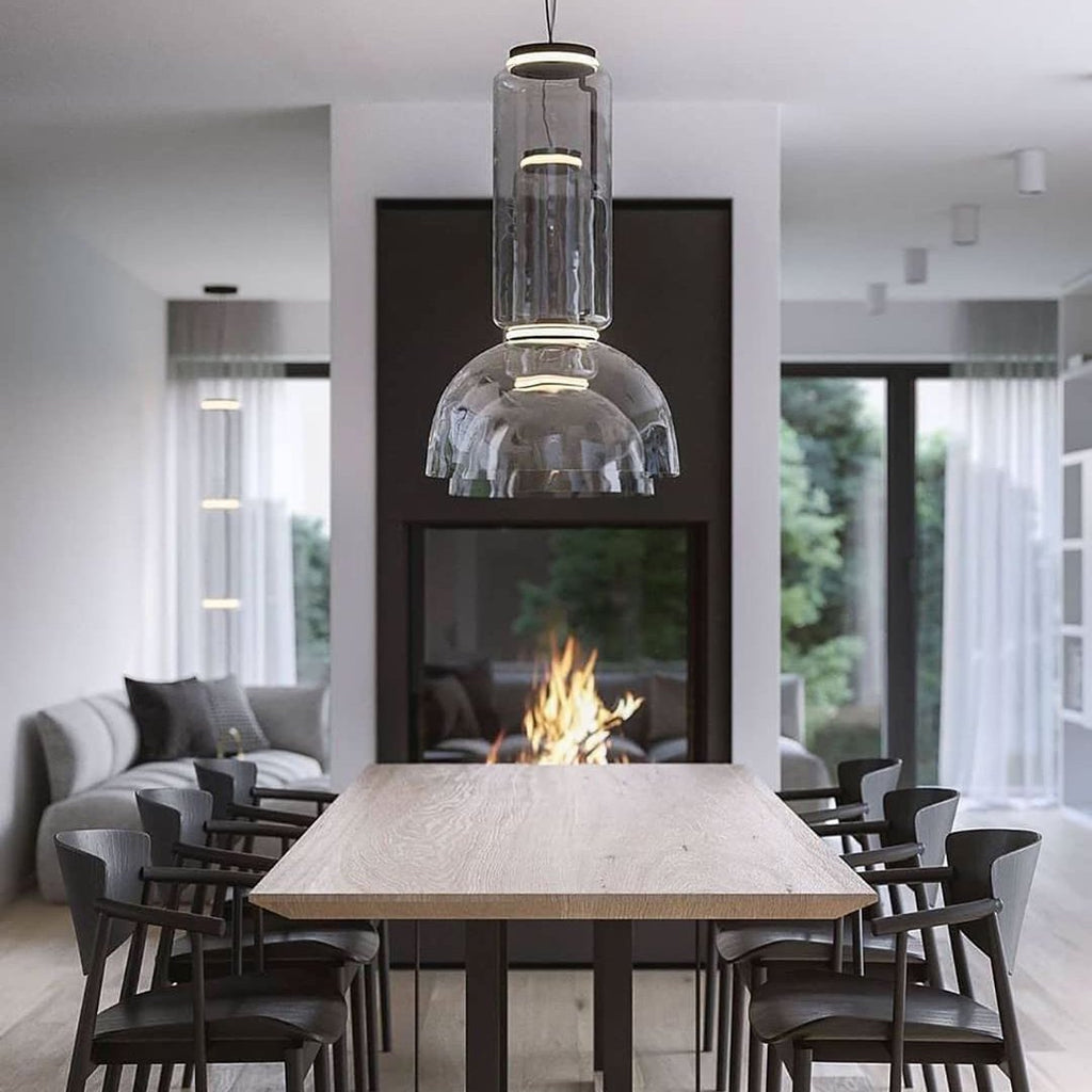 This Clérachic pendant's dome-shaped shade hangs low above a dining table beside a lit two-sided fireplace.