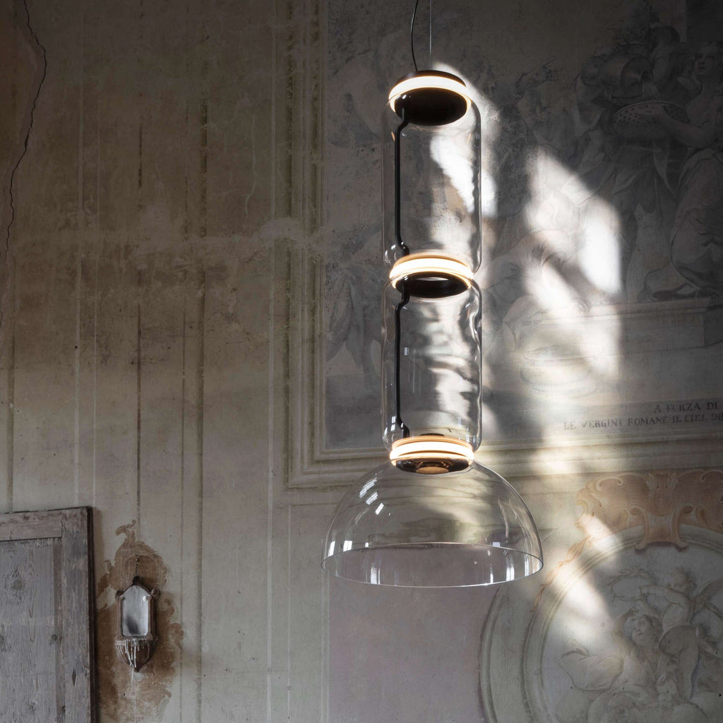 Close view of this Clérachic pendant's dome-shaped shade catching light against a frescoed wall.